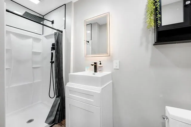 a bathroom with a shower a sink and a mirror