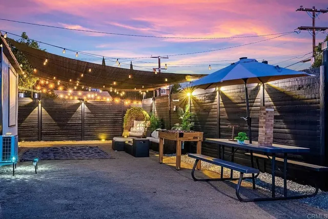 a view of patio with chairs and table under an umbrella