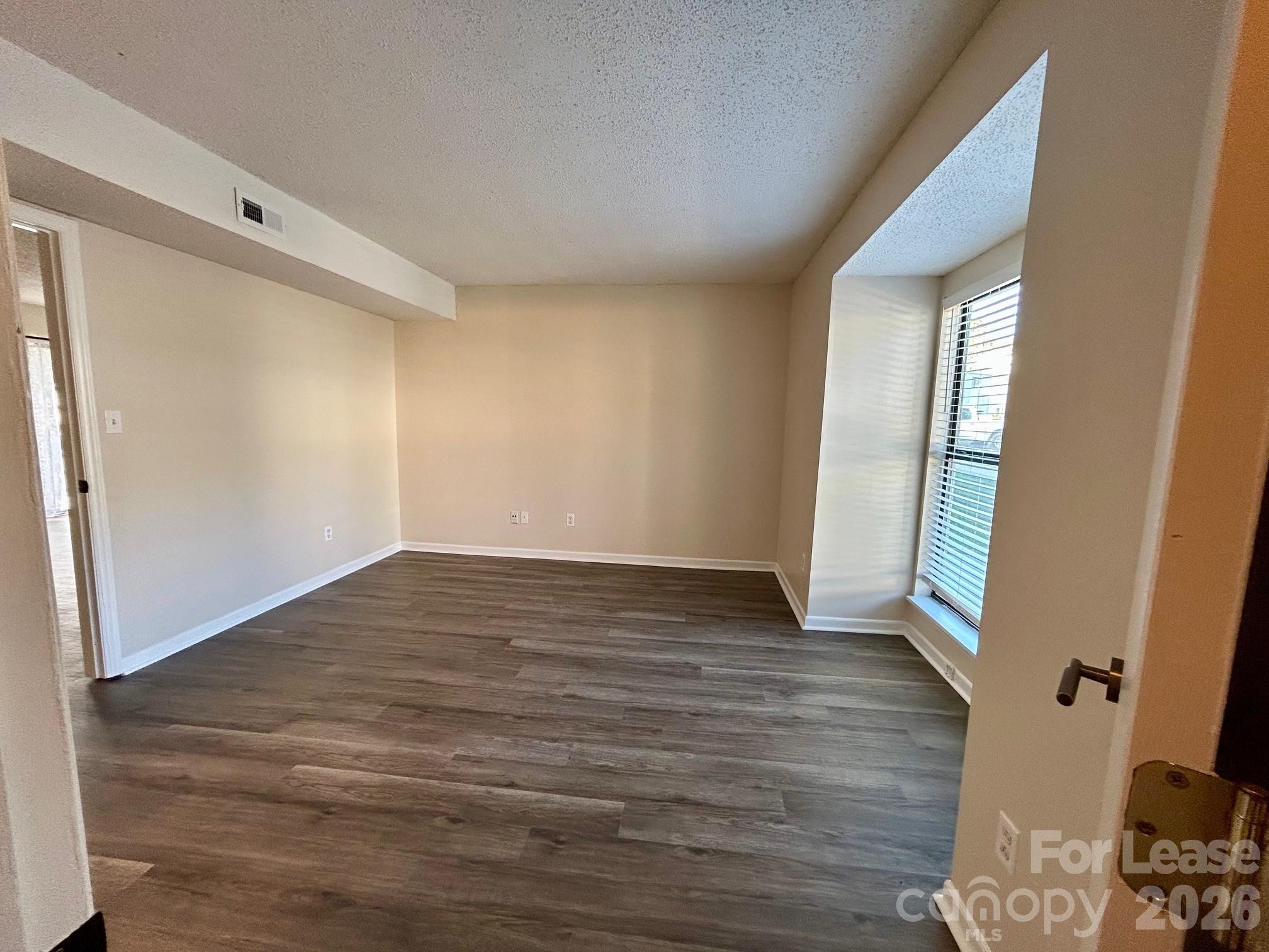 11028 Harrowfield Road Charlotte, NC 28226 - Photo 10 of 15 a view of an empty room with wooden floor and a window