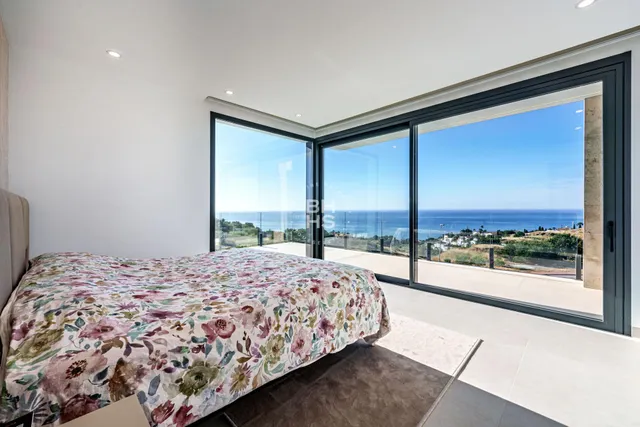 a bedroom with a large bed and a balcony view