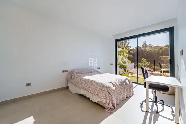 a bedroom with a bed and large window