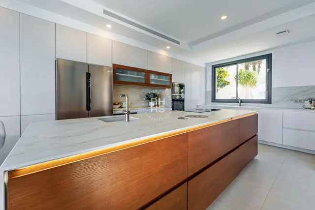 a large kitchen with kitchen island a sink stainless steel appliances and windows