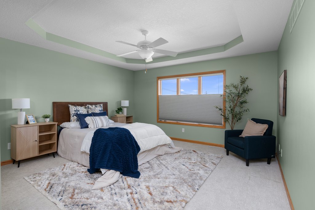 1126 West Le Claire Road Eldridge, IA 52748 - Photo 11 of 44 a bedroom with a bed and a chandelier