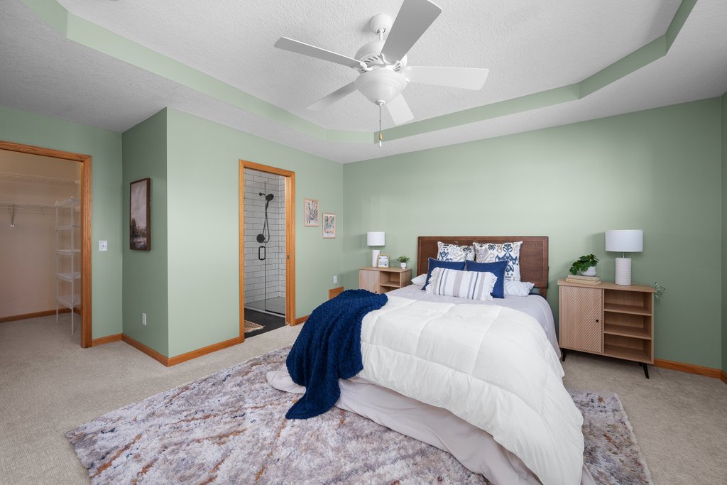 1126 West Le Claire Road Eldridge, IA 52748 - Photo 12 of 44 a bedroom with a bed and a chandelier