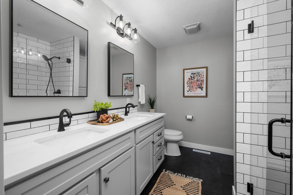 1126 West Le Claire Road Eldridge, IA 52748 - Photo 14 of 44 a bathroom with a sink a toilet and mirror
