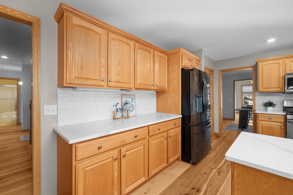 1126 West Le Claire Road Eldridge, IA 52748 - Photo 26 of 44 a kitchen with stainless steel appliances granite countertop a refrigerator sink and cabinets