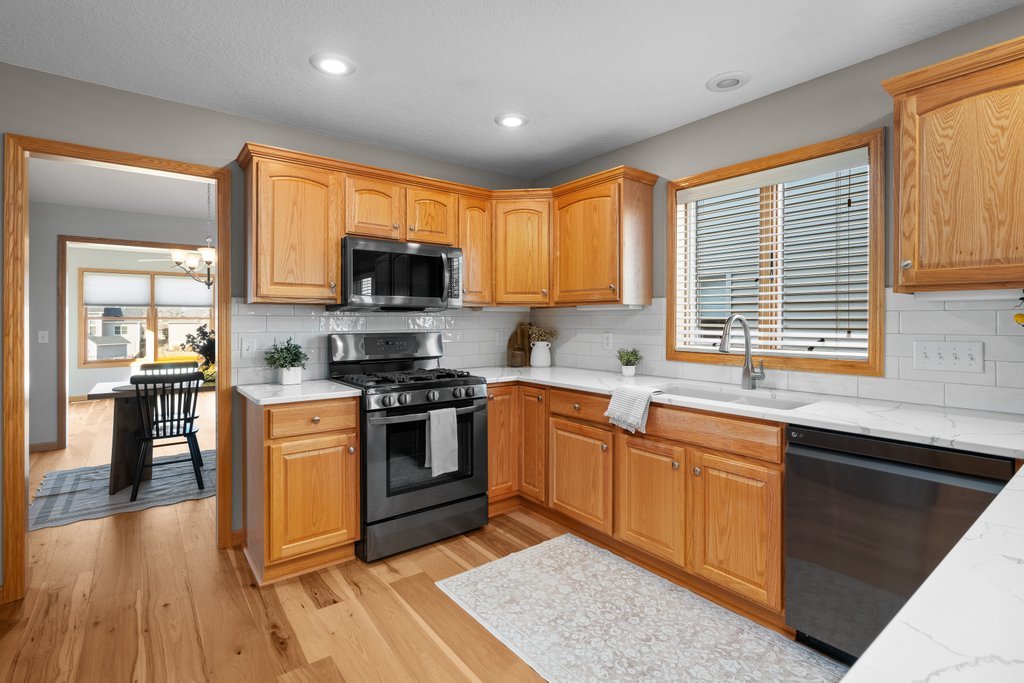 1126 West Le Claire Road Eldridge, IA 52748 - Photo 27 of 44 a kitchen with stainless steel appliances granite countertop a stove top oven a sink dishwasher and a microwave oven with cabinets