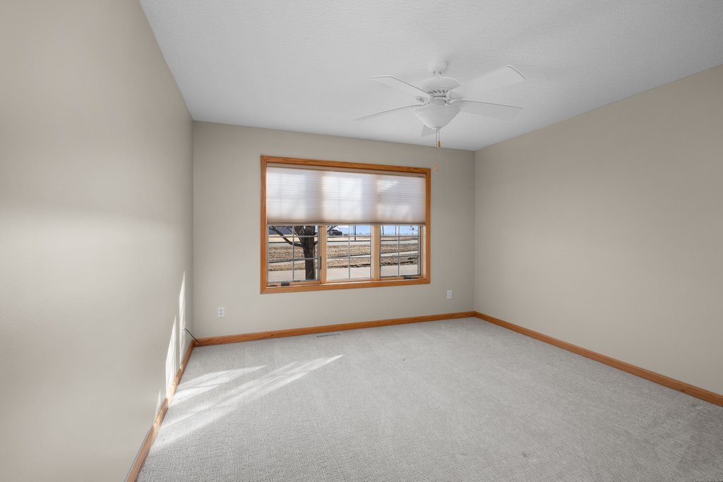 1126 West Le Claire Road Eldridge, IA 52748 - Photo 30 of 44 an empty room with a window and a ceiling fan