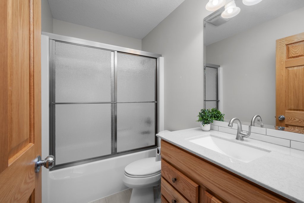 1126 West Le Claire Road Eldridge, IA 52748 - Photo 32 of 44 a bathroom with a sink toilet and shower