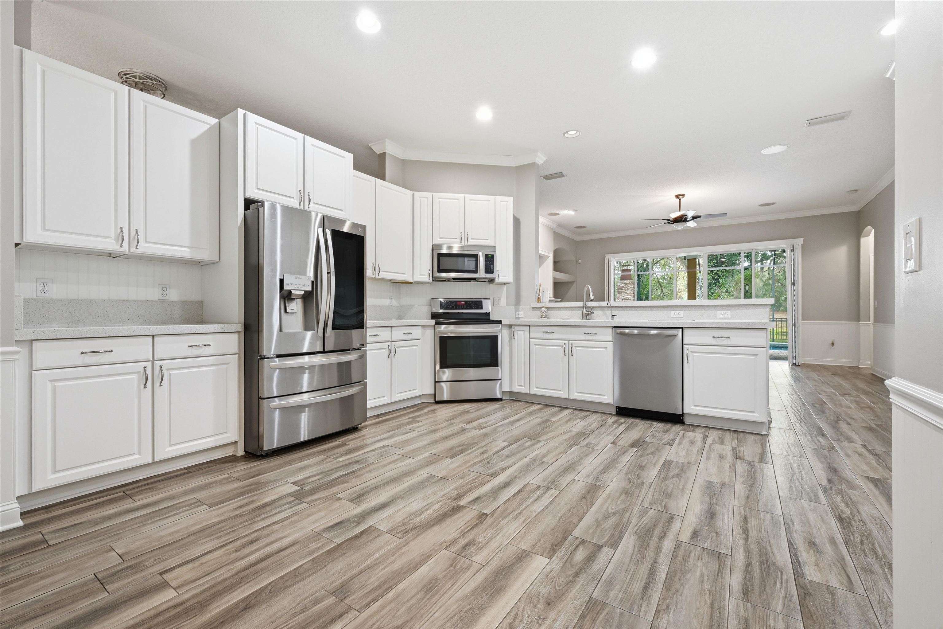 121 Edge Of Woods Road St. Augustine, FL 32092 - Photo 9 of 53 a kitchen with white cabinets and stainless steel appliances