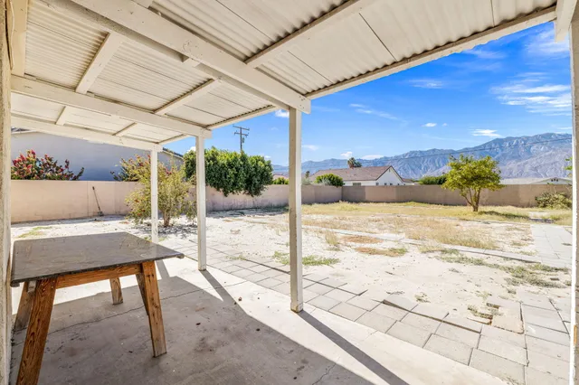 a view of a patio with a table and chairs under an umbrella