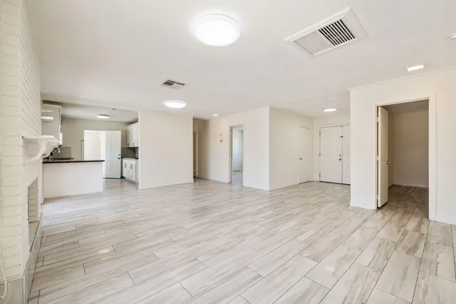 a view of a big room with wooden floor and a kitchen