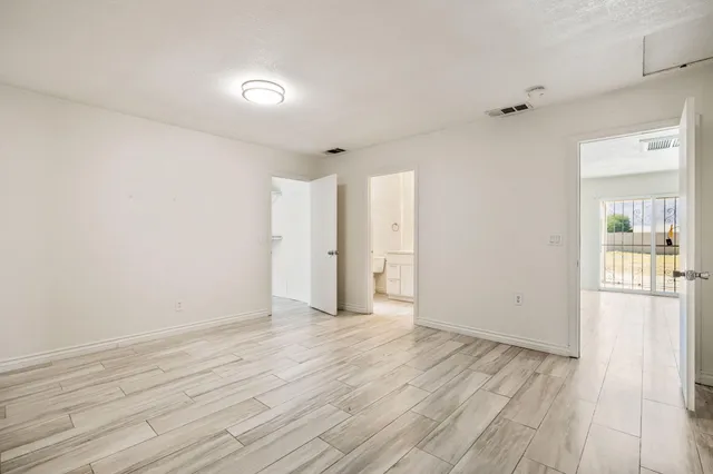 a view of an empty room with wooden floor