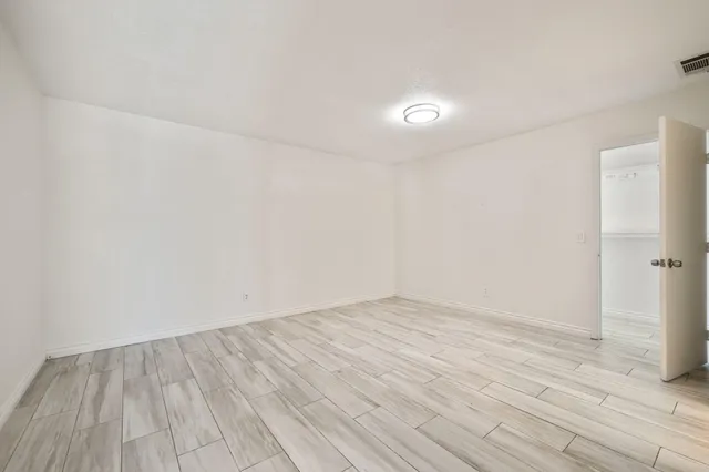 a view of an empty room with wooden floor