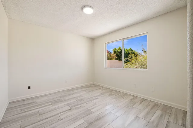 an empty room with wooden floor and window