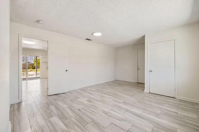 a view of empty room with wooden floor