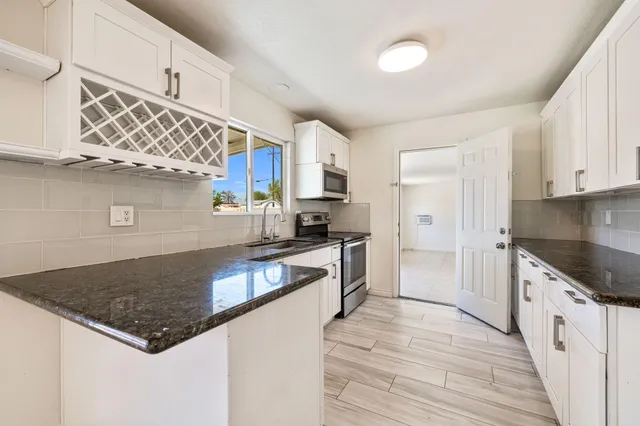 a kitchen with stainless steel appliances granite countertop a sink stove and refrigerator