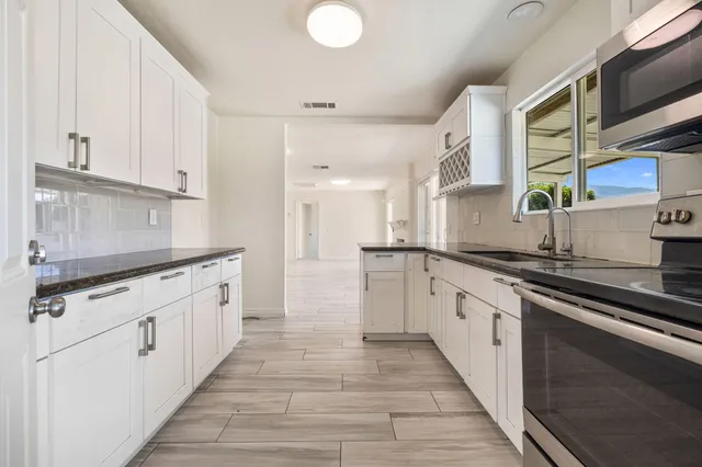 a kitchen with stainless steel appliances granite countertop a sink and a stove
