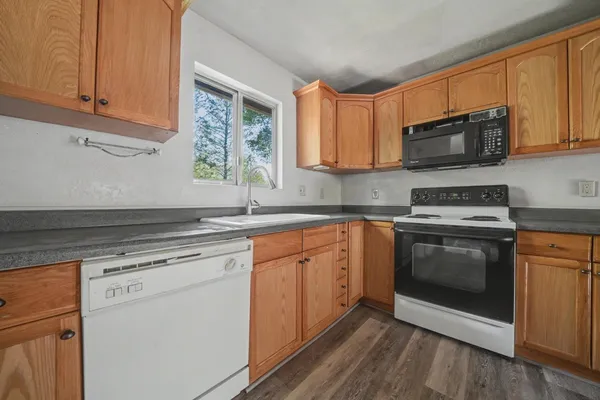 a kitchen with stainless steel appliances granite countertop a stove a sink and a microwave