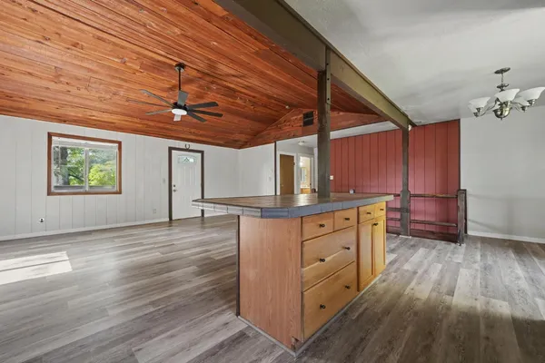 a kitchen with cabinets wooden floor and a window