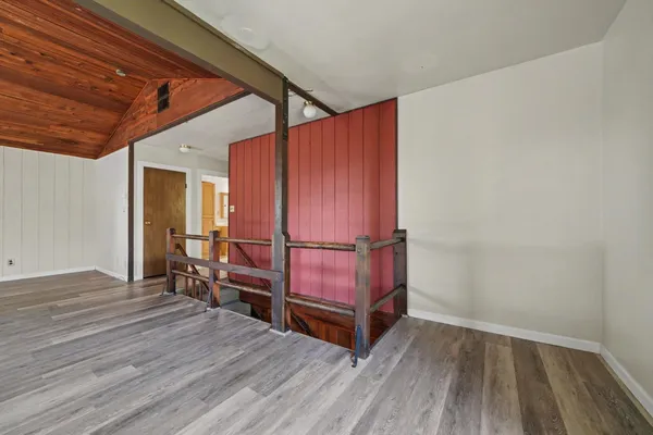 a view of a room with wooden floor lounge chair and windows