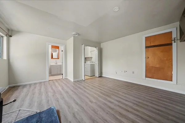 a view of a livingroom with wooden floor and furniture