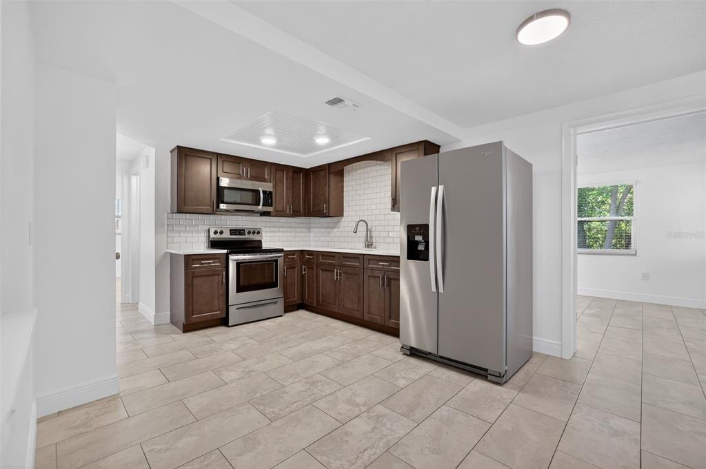 10914 Leeds Road Port Richey, FL 34668 - Photo 8 of 24 a kitchen with stainless steel appliances a refrigerator and a stove top oven