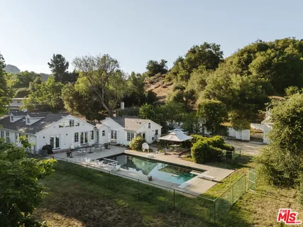 a view of house with outdoor space and swimming pool
