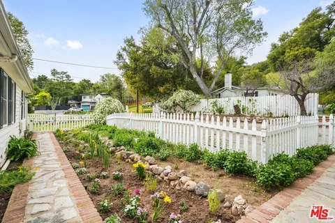 a living room with furniture large windows and wooden floor