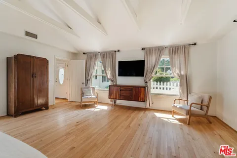 a front view of a house with a garden and trees