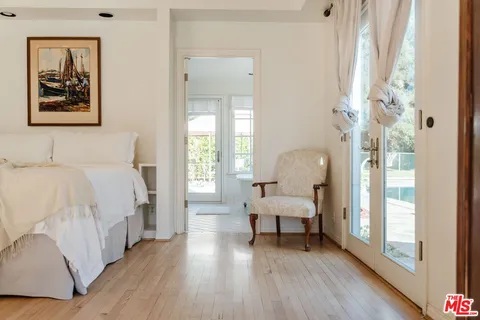 a view of house with outdoor seating area and trees around
