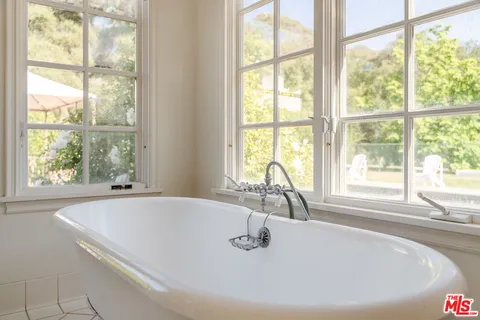 a view of swimming pool with outdoor seating and trees in the background