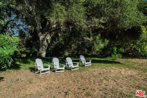 a view of a hallway to a house with wooden floor and furniture