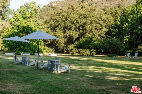 a view of a house with pool and chairs
