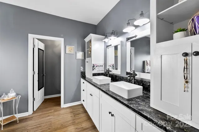 a spacious bathroom with a granite countertop sink and a mirror