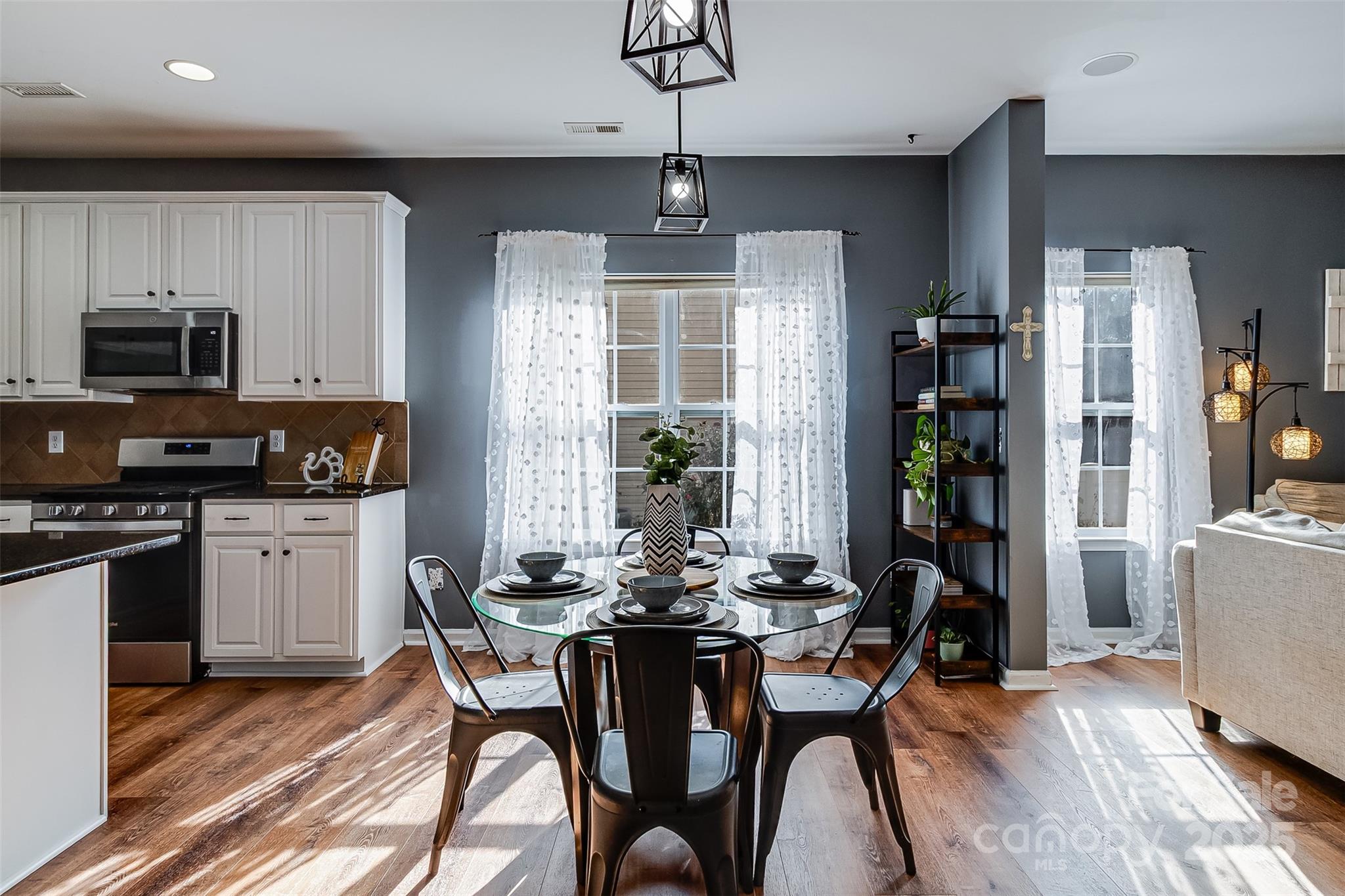 224 Morning Dew Lane Mount Holly, NC 28120 - Photo 13 of 48 a kitchen with stainless steel appliances granite countertop a stove a refrigerator a sink a dining table and chairs with wooden floor