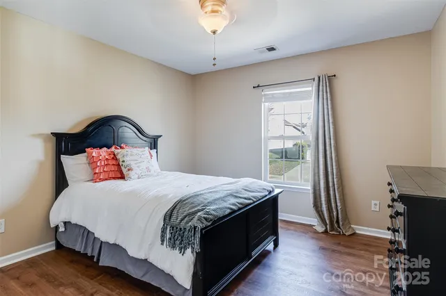 a view of a backyard with wooden fence and large trees