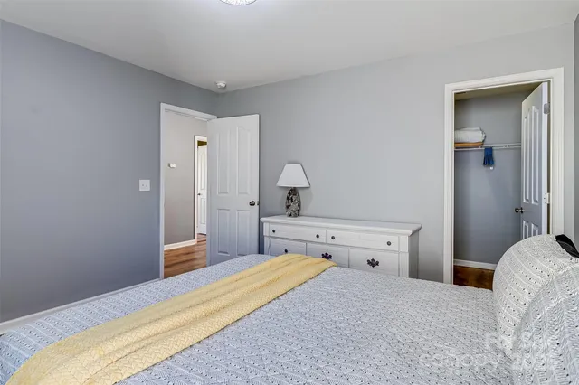 an aerial view of a swimming pool with a yard and trees