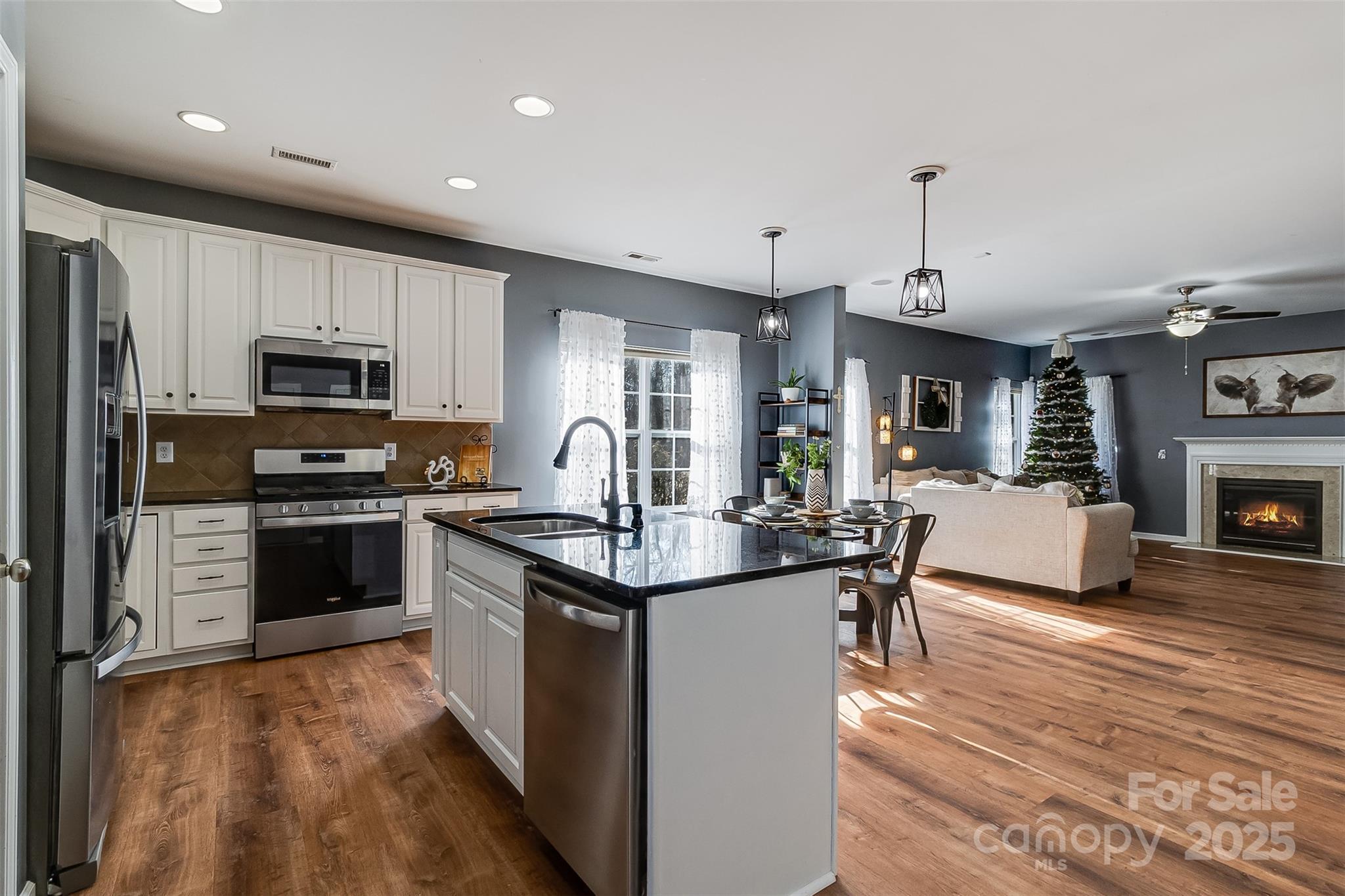 224 Morning Dew Lane Mount Holly, NC 28120 - Photo 9 of 48 a kitchen with kitchen island granite countertop a stove top oven a sink dishwasher a dining table and chairs with wooden floor