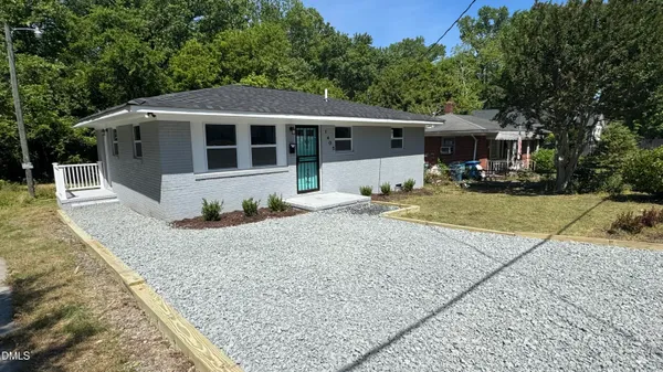 a front view of a house with swimming pool and sitting area
