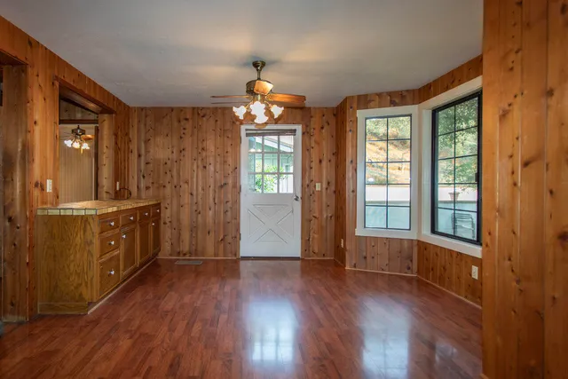 a view of a livingroom with wooden floor and a large window