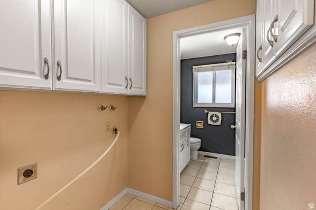728 400 East Orem, UT 84097 - Photo 17 of 30 Laundry area featuring upper cabinetry with brushed nickel hardware, wall-mounted utility hookups, and ceramic tile flooring