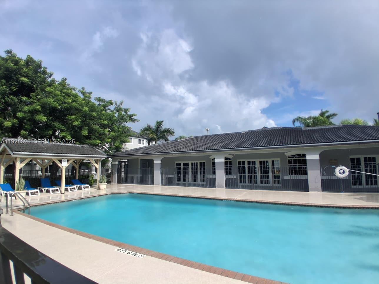 a view of house with a big yard and potted plants