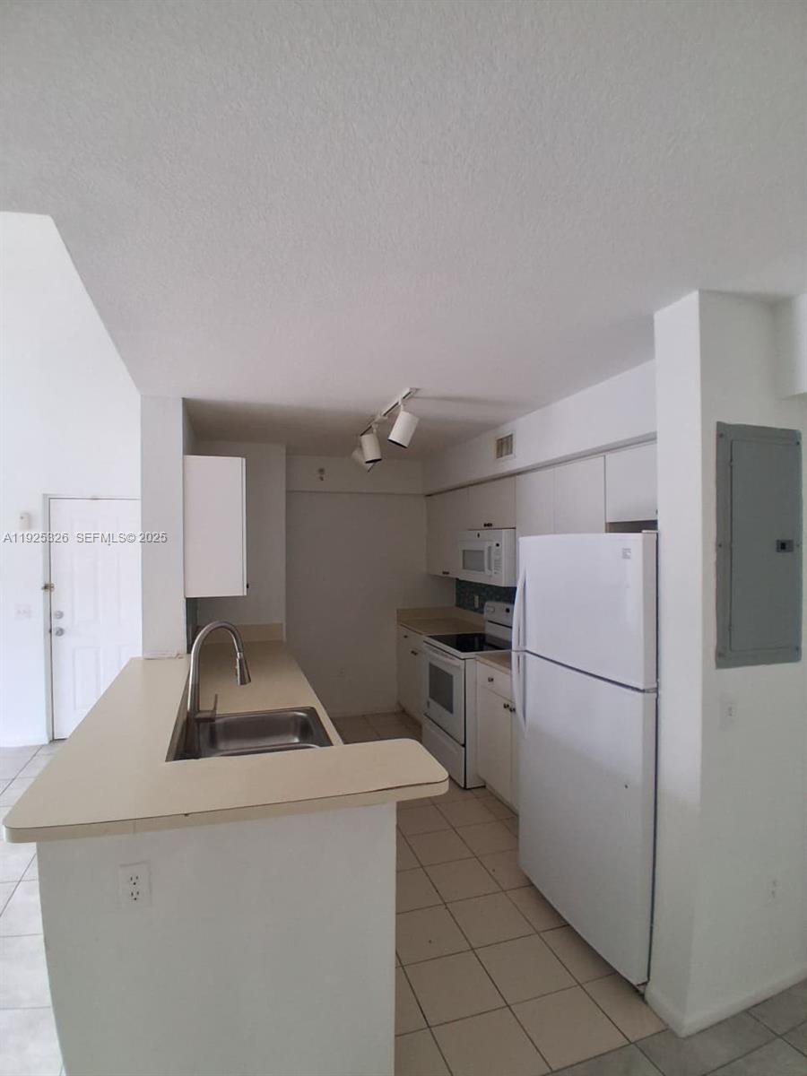 15460 Southwest 284th Street, Unit 4307 Homestead, FL 33033 - Photo 4 of 13 a kitchen with a refrigerator and a sink