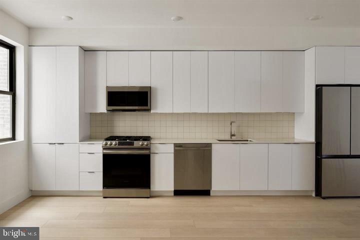 2007 Cambridge Street Philadelphia, PA 19130 - Photo 12 of 33 a kitchen with a refrigerator stove and white cabinets