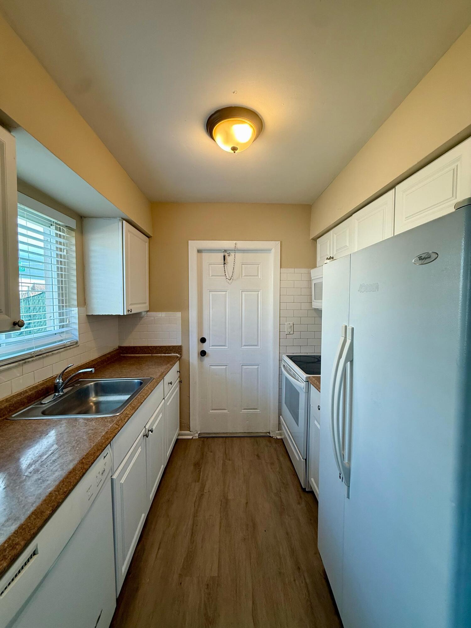 2925 Northeast 7th Avenue, Unit A Pompano Beach, FL 33064 - Photo 13 of 14 a kitchen with granite countertop a sink and refrigerator