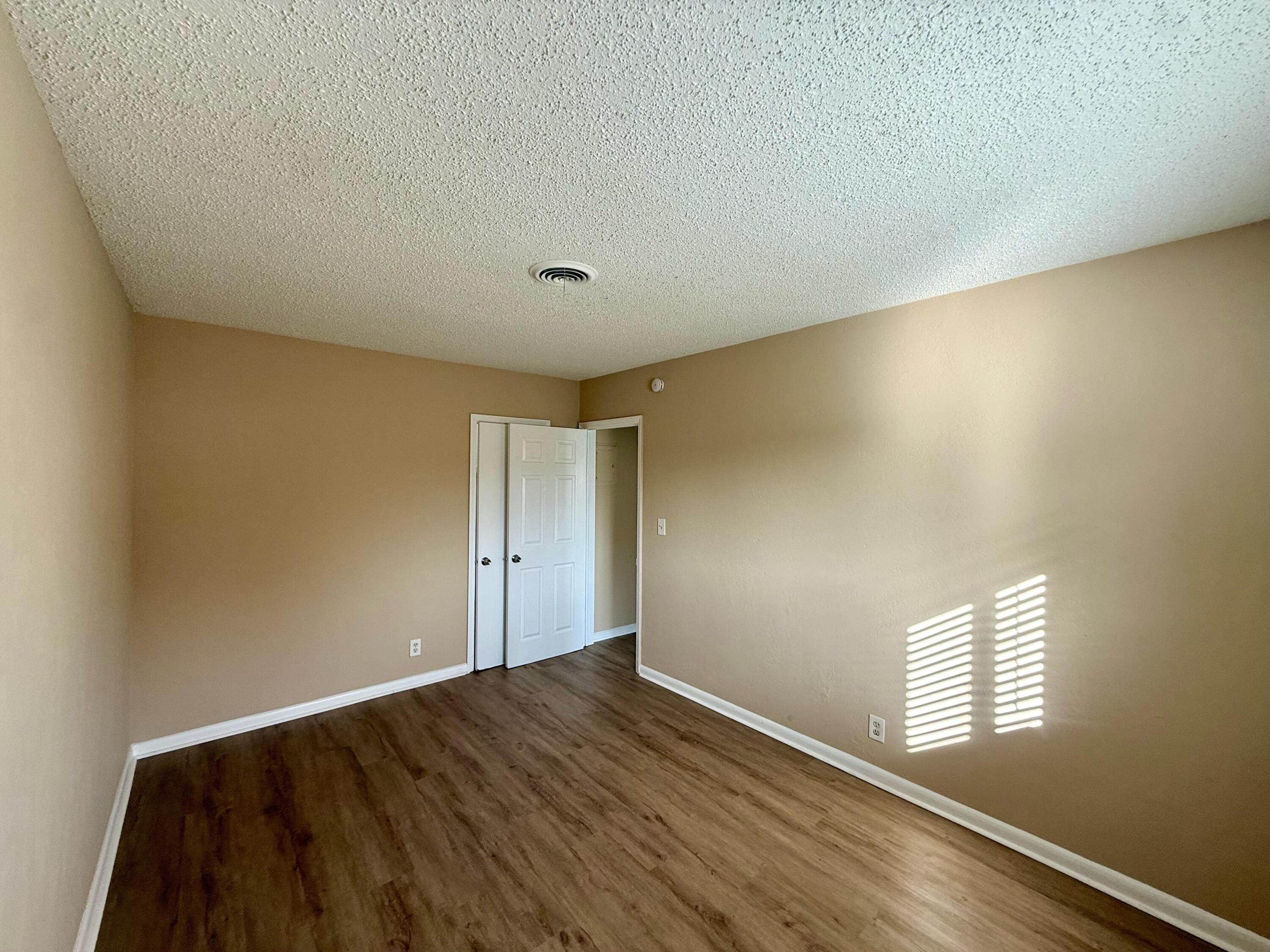 2925 Northeast 7th Avenue, Unit A Pompano Beach, FL 33064 - Photo 9 of 14 an empty room with wooden floor and windows
