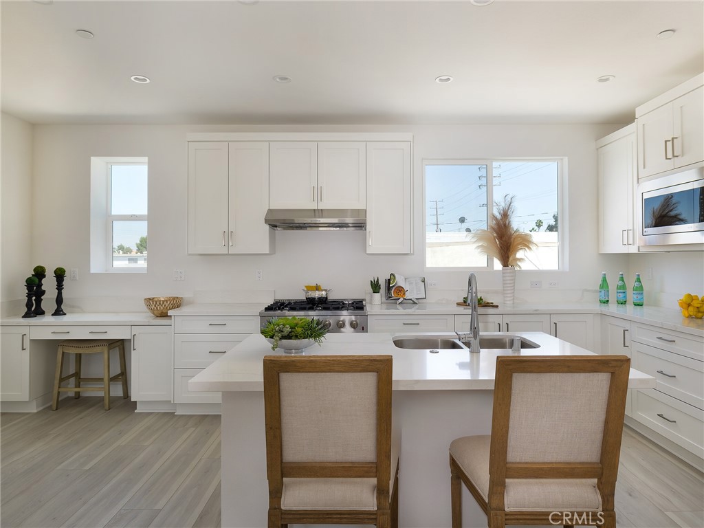 121 East 223rd Street, Unit 3 Carson, CA 90745 - Photo 9 of 34 a kitchen with a sink a stove cabinets and wooden floor