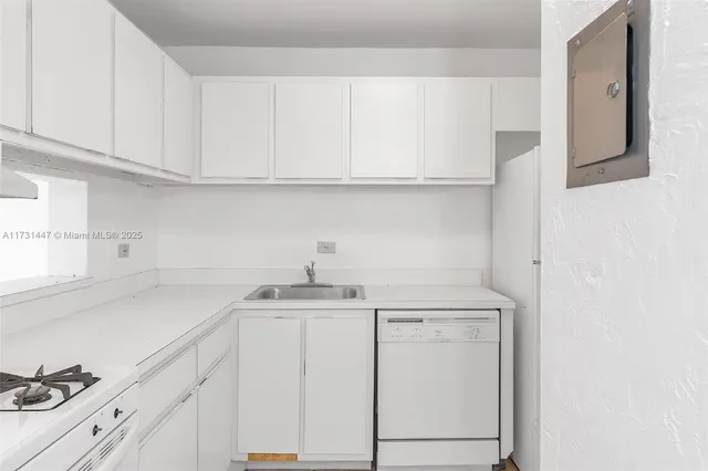 a kitchen with white cabinets and sink