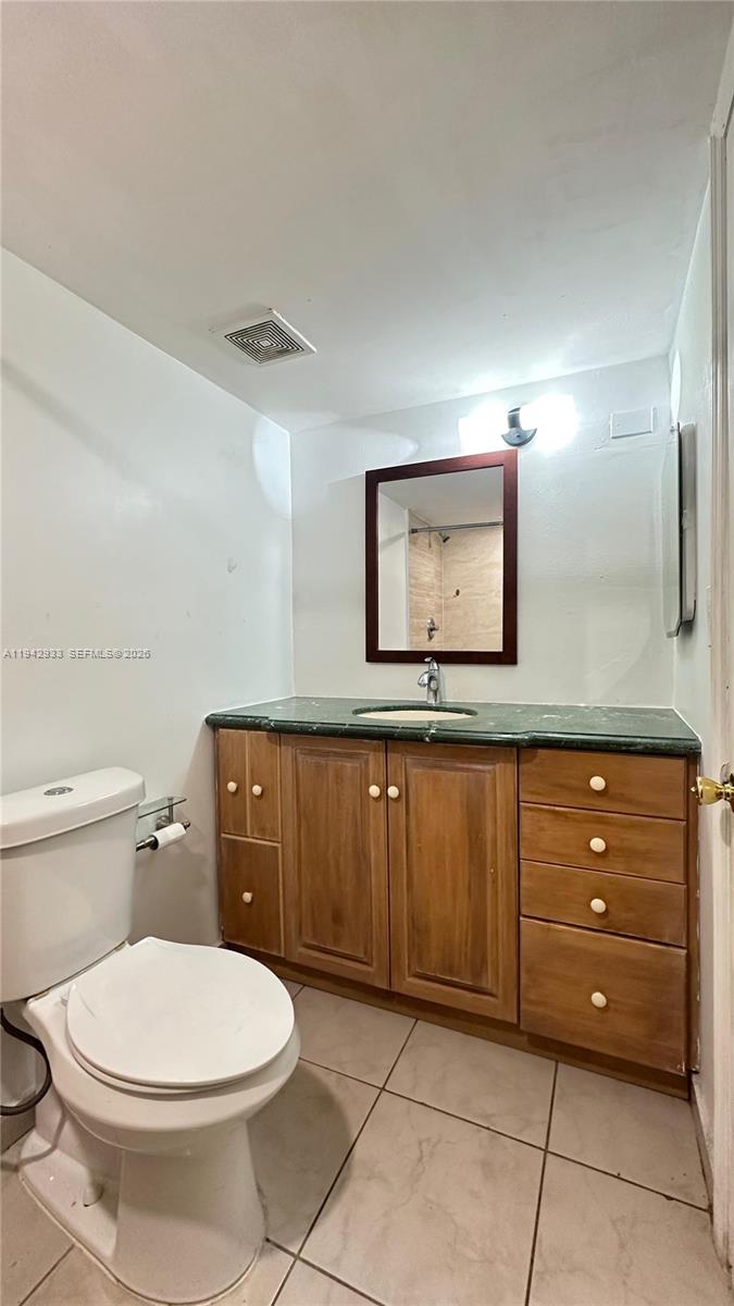 606 West 81st Street, Unit 305 Hialeah, FL 33014 - Photo 8 of 11 a bathroom with a toilet a sink and mirror